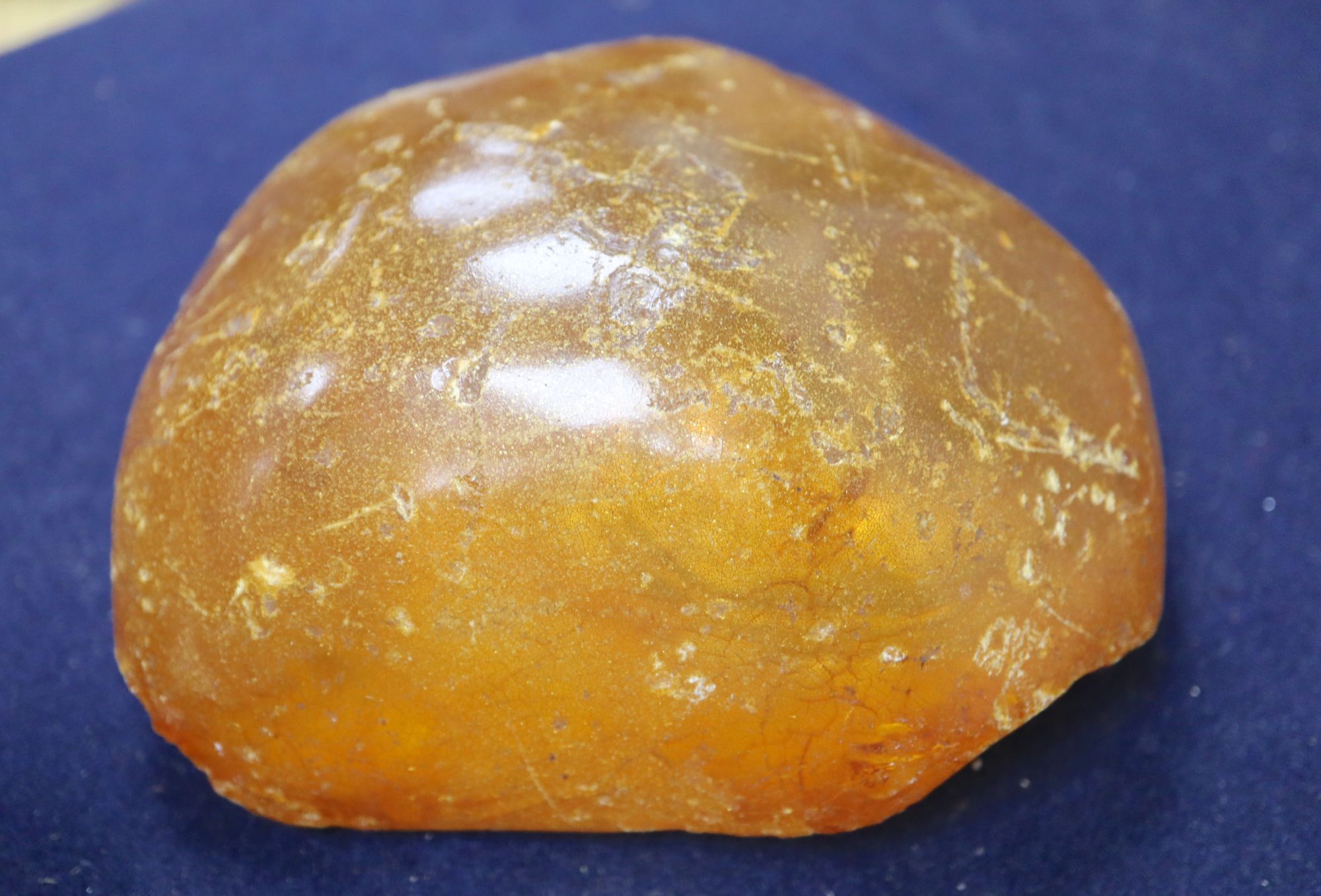 An amber necklace(a.f.) gross 85 grams, four assorted amber pebbles, 528 grams, a carved amber pendant